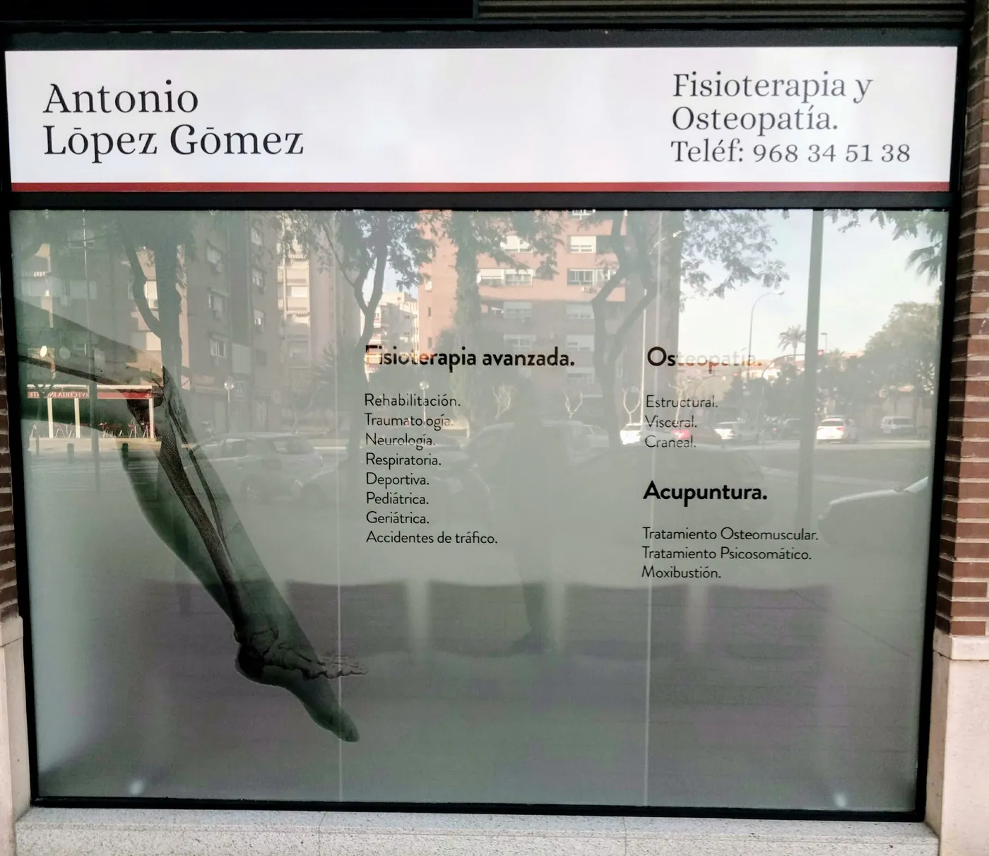 Escaparate esmerilado con la lista de especialidades de la clínica