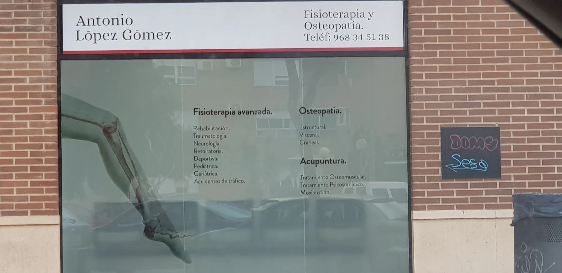 Fachada de ladrillo con el rótulo Antonio López Gómez, Fisioterapia y Osteopatía