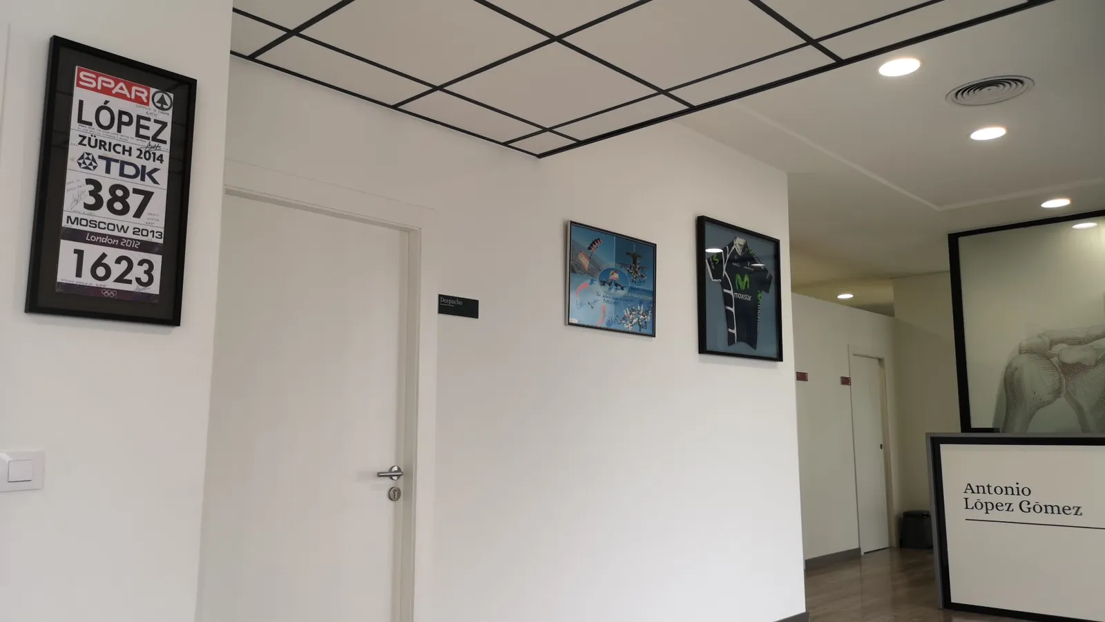 Sala de espera con dorsales y camisetas firmadas enmarcadas